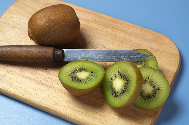 Kiwi mûrs et tranche sur planche de cuisine en bois