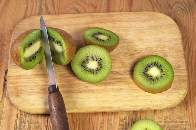 Kiwi mûrs et tranche sur la vieille table en bois