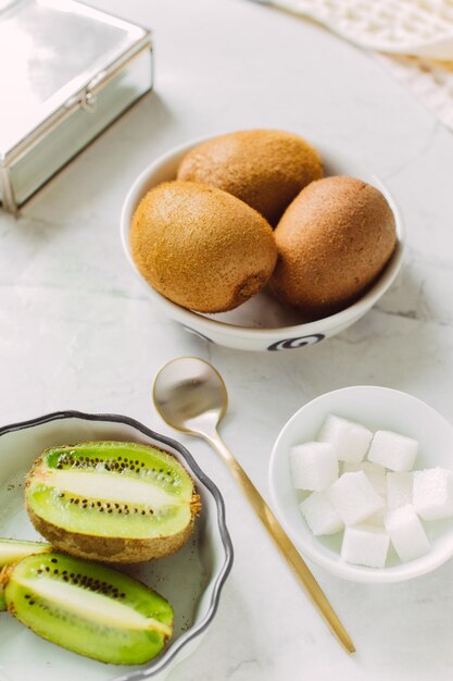 kiwi tranché dans une assiette sur fond clair