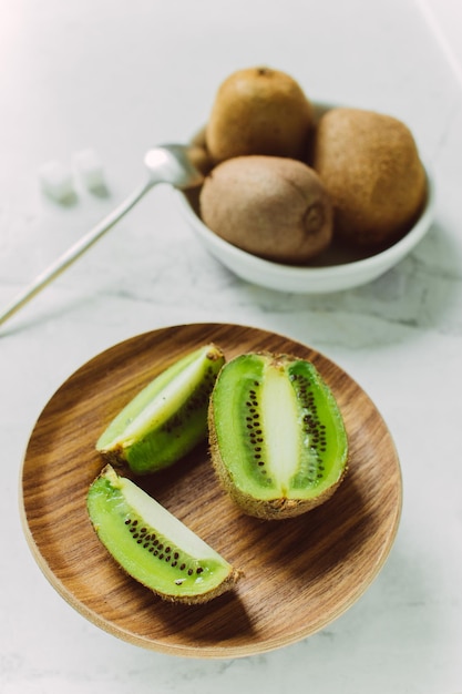 kiwi tranché dans une assiette sur fond clair