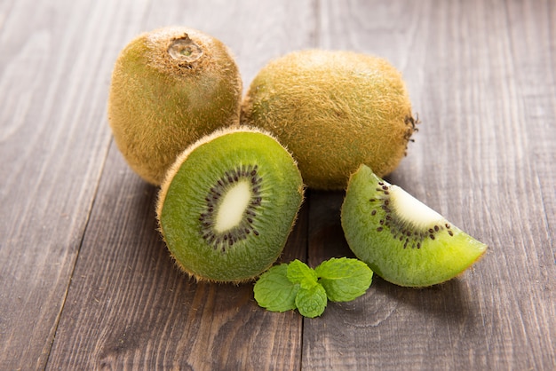 Kiwis frais sur fond de bois brun.