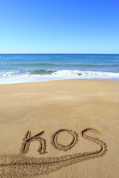 Kos écrit sur la plage de sable