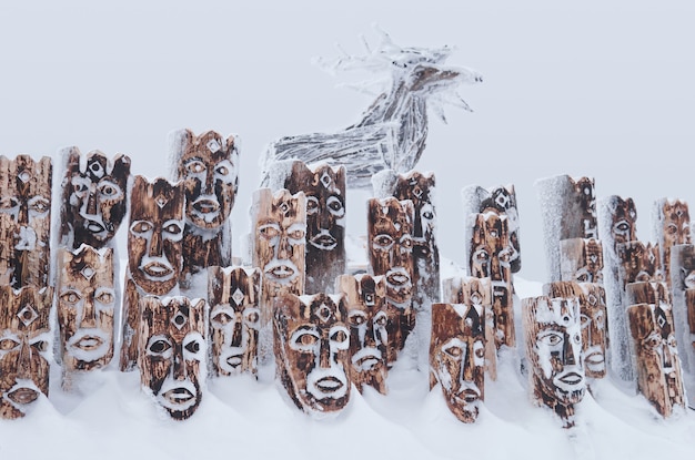Krai de Perm, Russie - 2 janvier 2021 : objet d'art en bois couvert de neige - groupe d'idoles représentant des figures anthropomorphes et des élans