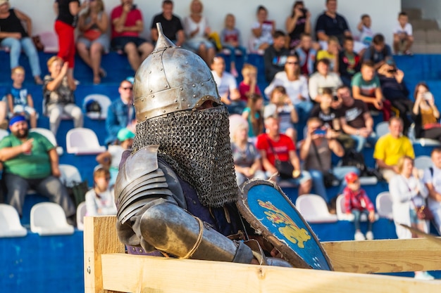 Photo krasyliv, ukraine. septembre 2019. un homme en costume de chevalier médiéval sur la tribune d'arrière-plan avec les spectateurs_