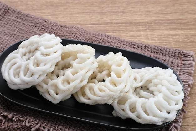 Krupuk ou Kerupuk Indonésie craquelins traditionnels servis sur une plaque noire sur fond de bois