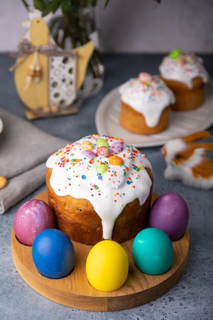 Kulich de Pâques avec des fruits confits en glaçage blanc avec des éclaboussures colorées et des œufs peints Pâques traditionnelles Pâques vacances Pâques Focus sélectif en gros plan