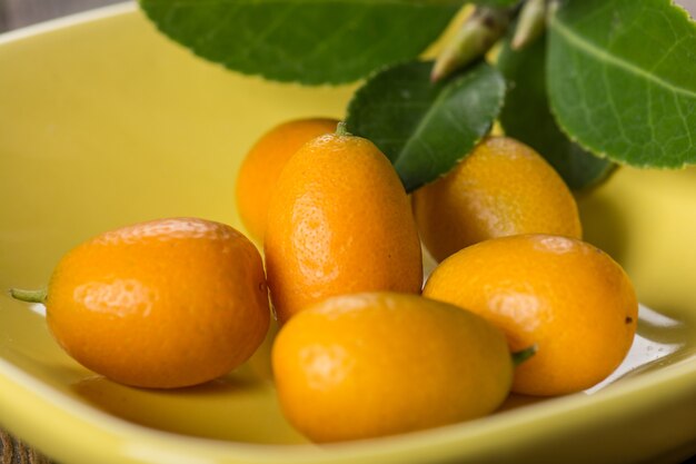 Kumquat sur plaque à table en bois