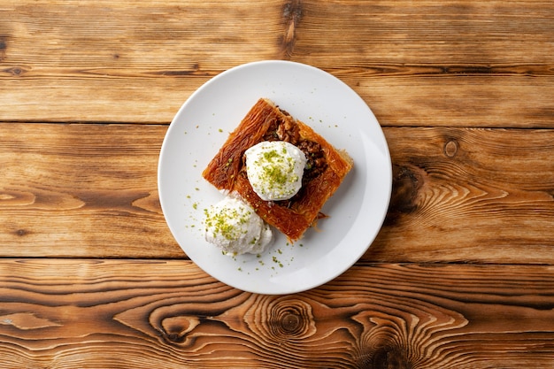 Kunefe de dessert turc servi avec de la crème glacée sur fond de bois