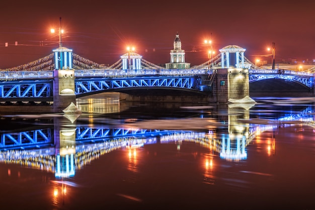 Photo kunstkamera et le pont du palais bleu du nouvel an à saint-pétersbourg par une nuit d'hiver et son reflet dans la neva