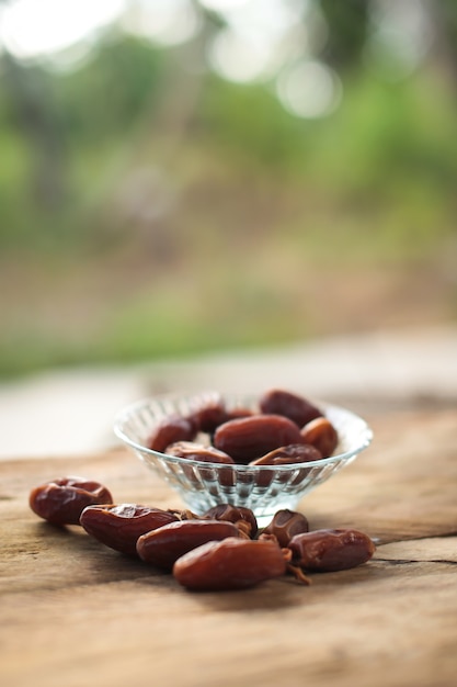 Photo kurma ou dates séchées, fond en bois de chapelet.