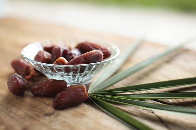 Photo kurma ou dattes séchées, chapelet sur fond en bois.