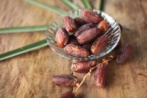 Kurma ou dattes séchées, chapelet sur fond en bois.