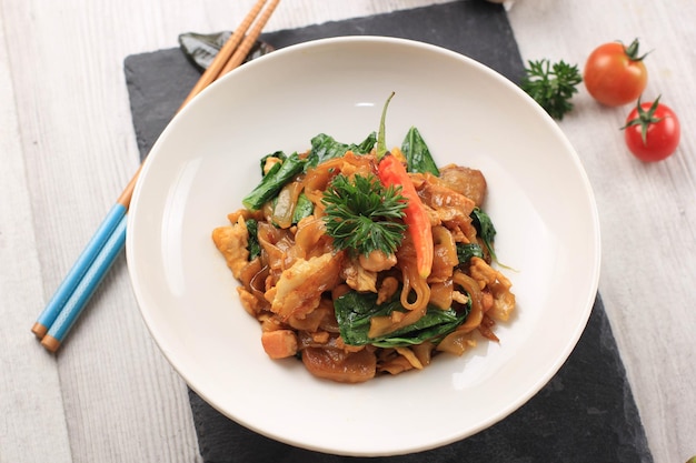 Photo kwetiau est une nouille chinoise populaire en indonésie, cuite par friture avec des légumes et du poulet, des fruits de mer ou de la viande