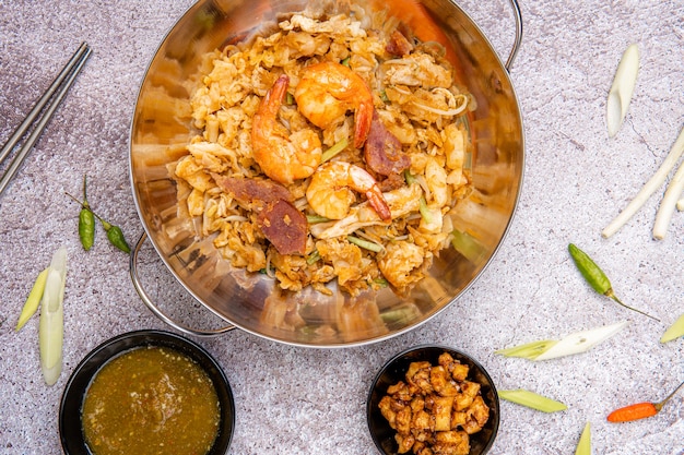 Kwetiau goreng medan ou char kway teow Il est fabriqué à partir de nouilles sautées dans de l'huile de cuisson avec de l'ail, de l'oignon ou des échalotes, des boulettes de viande de bakso en tranches de crevettes frites