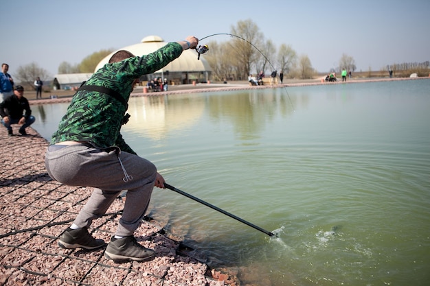 Kyiv, Ukraine 16 avril 2018. Un pêcheur caucasien attrape du poisson avec une épuisette sur le lac.