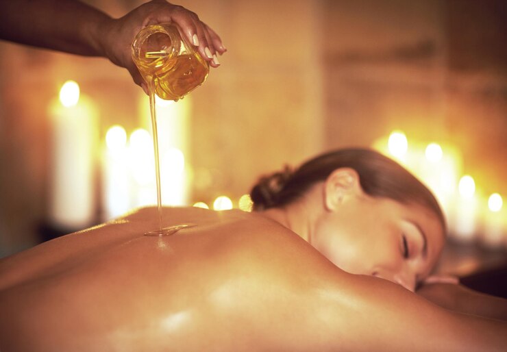 Photo là où le stress se termine et où la relaxation commence photo d'une masseuse versant de l'huile sur le dos d'une femme avant son massage