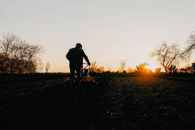 labourer un champ avec un tracteur à conducteur marchant dans une ferme