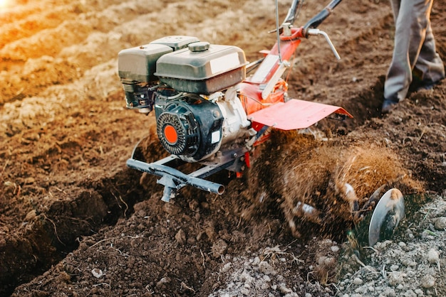 labourer un champ avec un tracteur à conducteur marchant dans une ferme