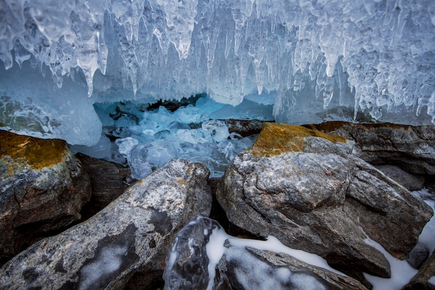 Le lac Baïkal est une journée d'hiver glaciale. Le plus grand lac d'eau douce. Le lac Baïkal est recouvert de glace et de neige, de forts froids et gelées, d'une épaisse glace bleu clair. Des glaçons pendent aux rochers. Patrimoine du lieu étonnant