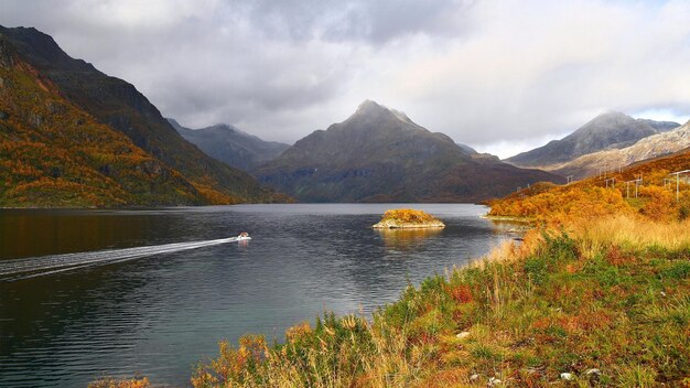 un lac avec un bateau et une montagne en arrière-plan