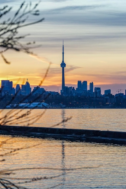Lac avec des bâtiments en arrière-plan contre le ciel au coucher du soleil