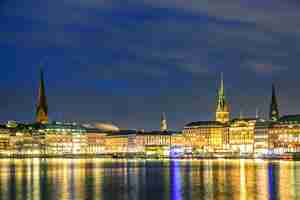 Photo lac binnenalster avec centre-ville illuminé à hambourg, allemagne pendant le coucher du soleil crépuscule.