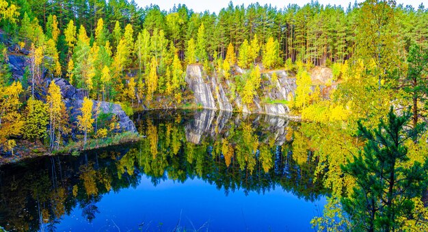 Un lac dans les montagnes avec une forêt d'automne sur les rives.