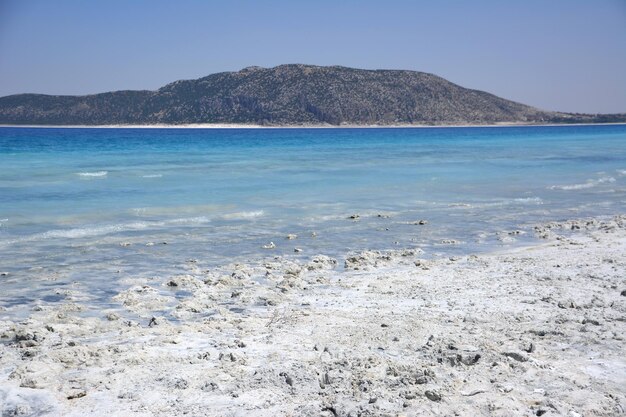 lac avec de l'eau bleu clair et du sable blanc en journée ensoleillée