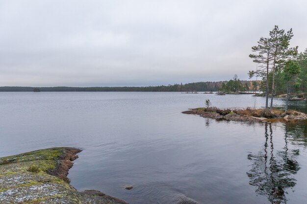 Lac, eau calme, reflet de la forêt dans l'eau, nuages