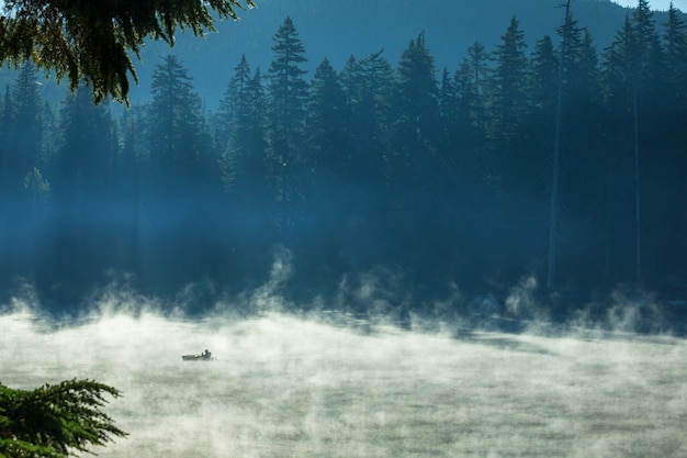 Lac de montagne brumeux au petit matin serein dans les montagnes.