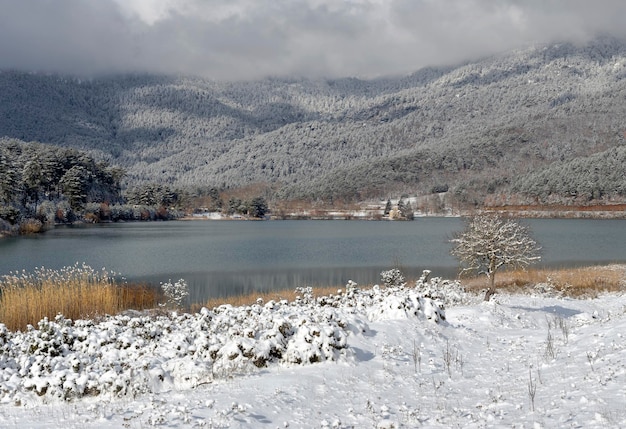 Lac de montagne Feneos et montagnes autour en hiver sur une journée ensoleillée enneigée Grèce Péloponnèse Corinthie montagneuse