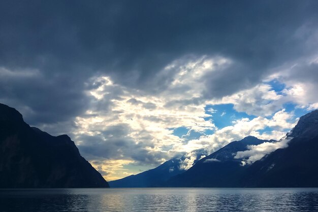 Lac de montagne avec des nuages dramatiques dans un ciel orageux au crépuscule bleu