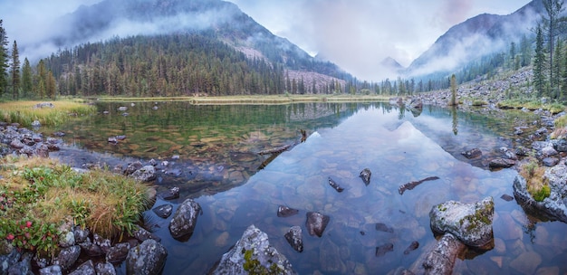 Lac de montagne le soir léger temps nuageux reflet dans l'eau