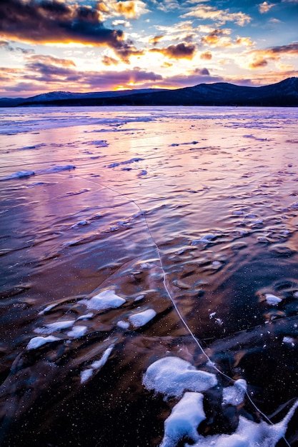 Lac recouvert de glace sur fond de lever de soleil