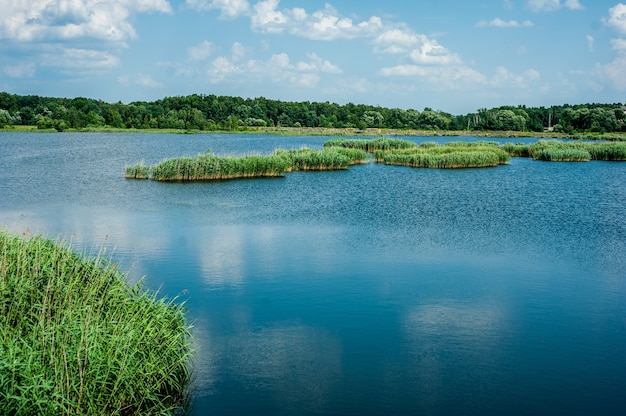 Lac sauvage en été Ciel bleu et nuages