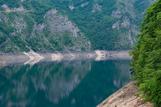 Le lac turquoise pittoresque est parmi les hautes montagnes