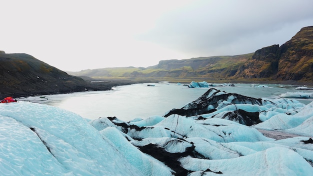 Lagon glaciaire islandais du Vatnajokull avec d'énormes blocs de glace dans des paysages arctiques couverts de gel, des icebergs de diamant gelés près des montagnes enneigées. Point de repère national polaire glacé. Tir à la main.