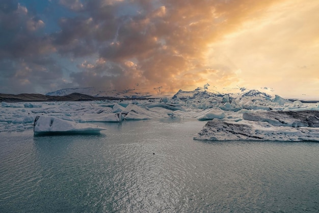 Lagon glaciaire pittoresque de jokulsarlon avec montagne en arrière-plan pendant le coucher du soleil