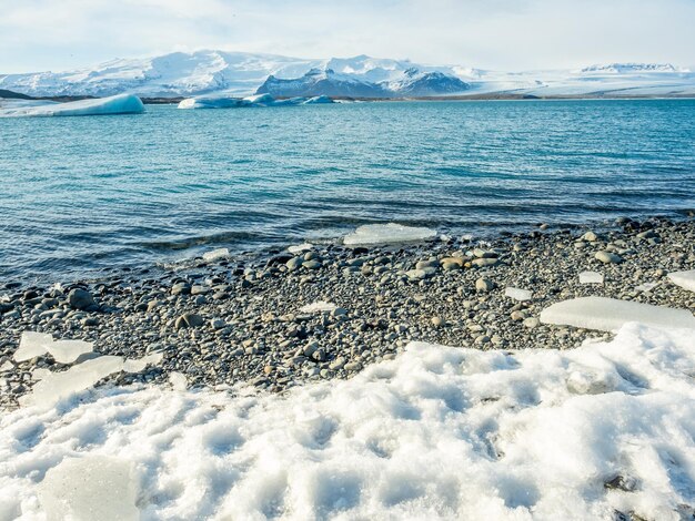 Lagune d'iceberg de Jokulsarlon avec glacier et grand iceberg sous un ciel bleu nuageux en Islande