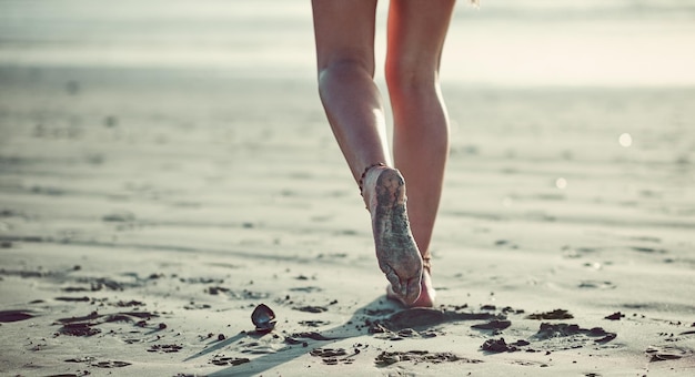 Laisser ses pieds la guider Photo recadrée d'une femme méconnaissable marchant sur la plage