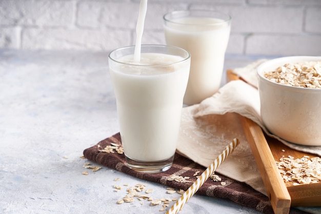 Lait alternatif sain. Lait de chêne fait maison en verre et bouteille sur une table lumineuse Sans lactose