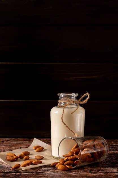 Lait d'amande dans une bouteille, sur fond de bois vintage foncé, avec copie-espace