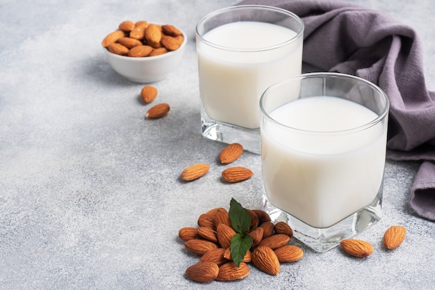 Lait d'amande dans des verres en verre sur fond gris