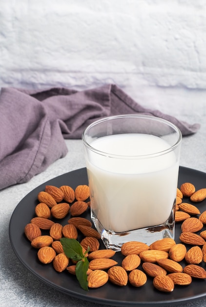 Lait d'amande dans des verres en verre sur une table en bois sombre.