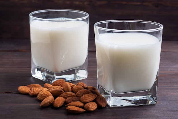 Lait d'amande dans des verres en verre sur une table en bois.