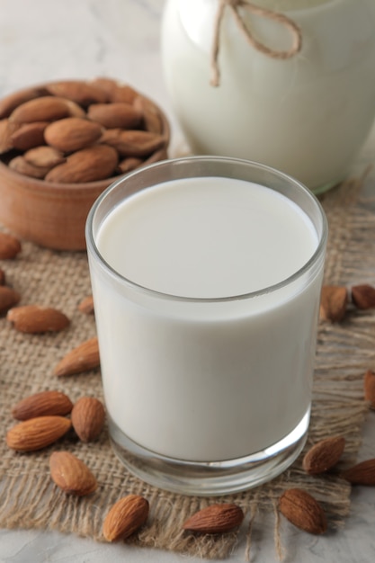 Lait d'amande frais dans un verre et noix d'amande