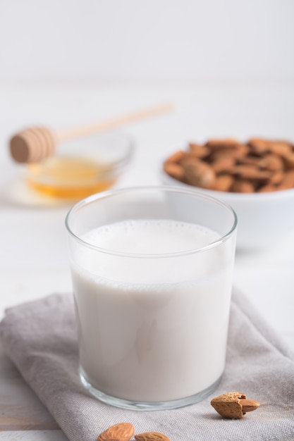 Lait d'amande et miel sur une table en bois blanc