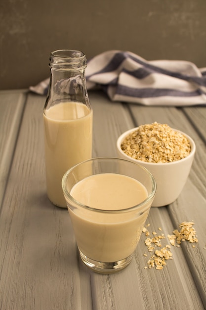 Lait d'avoine dans le verre sur le fond gris. Boisson saine.