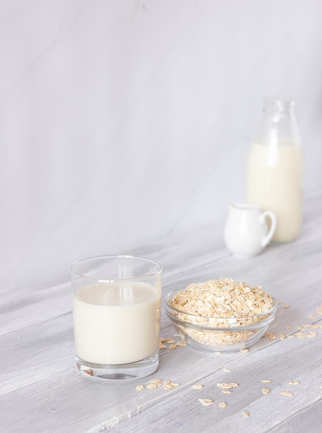 Lait d'avoine végétal en bouteille et flocons d'avoine