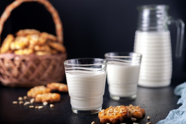 Lait avec des biscuits aux arachides maison fraîchement cuits sur un mur sombre